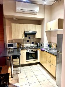 a kitchen with wooden cabinets and a stove top oven at Warm & Cozy Diamonds Hotel in Johannesburg +24 photos
