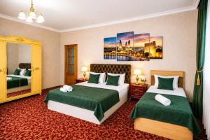 a hotel room with two beds and a mirror at Sultanahmet Hotel in Baku