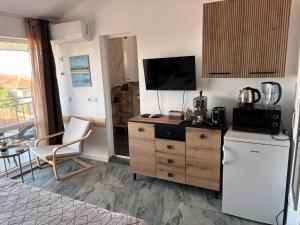 a kitchen with a refrigerator and a counter with a microwave at SummerBlue - Синьо лято in Lozenets