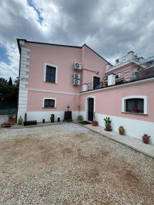 a pink house with a gravel driveway at B&B Casa Lydia in Lamezia Terme