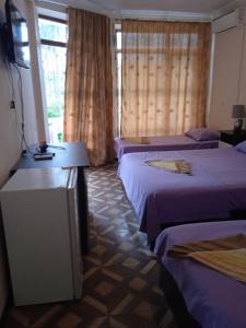 a hotel room with two beds and a television at Shekvetili Babi in Shekhvetili