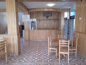 a dining room with a table and chairs and a refrigerator at Shekvetili Babi in Shekhvetili