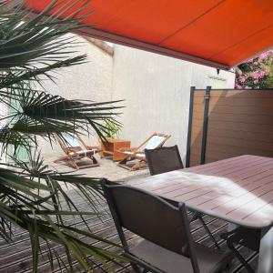 a wooden table and chairs on a patio at La Paloma in Aigues-Mortes