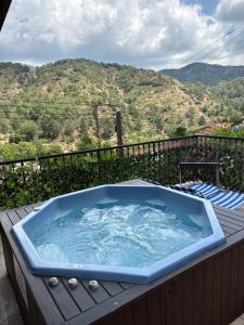 a jacuzzi tub on a wooden deck with a mountain at Love Holiday Suite 2 in Tris Elies