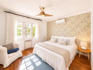a white bedroom with a bed and a chair at Aurora Boutique - Only Adults in Marbella
