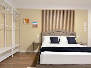 a bedroom with a large bed with blue and white pillows at Ugo Jacuzzi Apartment in Bologna