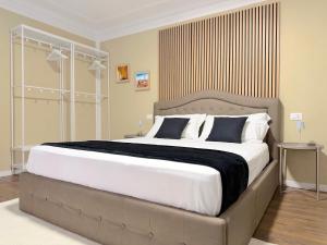 a bedroom with a large bed with white and blue pillows at Ugo Jacuzzi Apartment in Bologna +20 photos