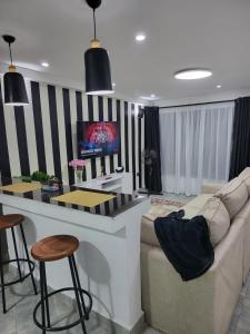 a living room with a couch and a bar at Private 2BR Bungalow in Quiet Green Gated Estate in Nairobi