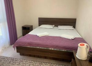 a bedroom with a large bed with a purple blanket at Дом у Айбека in Tamga