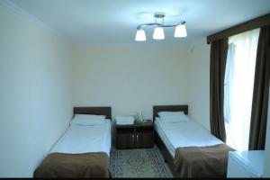 two beds in a room with blue walls and windows at Дом у Айбека in Tamga