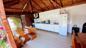 a kitchen with a white refrigerator and a table and a table and chairs at Casa Nicola in 2 Mai