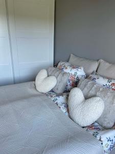 a bed with two heart shaped pillows on it at Bright & Spacious Apartment by the Sea, Free Parking, 10min to Airport, 12min to Ålesund in Ytterland +49 photos
