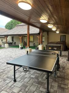 a ping pong table in a patio with a building at Furmint Vendégház in Tállya
