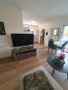 a living room with a flat screen tv and a table at Ferienwohnung Dreiländereck Gronau in Spechtholzhock