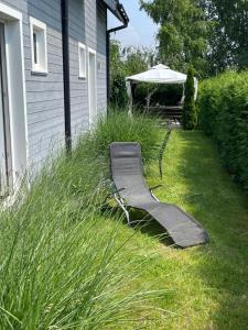 a slide in the grass next to a house at Aurora - Domki całoroczne nad morzem w Dziwnówku in Dziwnówek