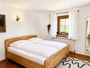 a bedroom with a bed with white sheets and a window at Landhaus Sisi - River&Pool in Bad Ischl +4 photos