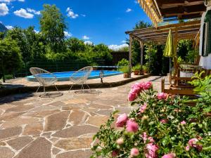 two chairs sitting on a patio near a swimming pool at Landhaus Sisi - River&Pool in Bad Ischl
