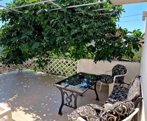 a table and chairs on a patio under a tree at Apartman Vesna in Leskovac