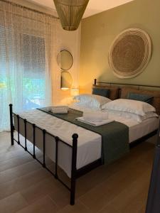 a bedroom with a large bed with white sheets at DD apartments & suites in Paralia Katerinis