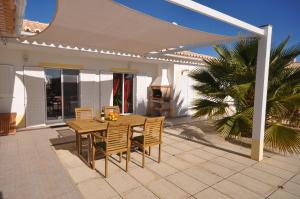 
a patio area with a table, chairs, and a patio umbrella at Casa Sol in Aljezur
