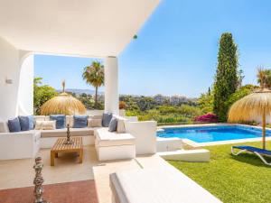 a living room with white furniture and a swimming pool at Aurora Boutique - Only Adults in Marbella