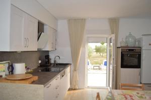a kitchen with a sink and a door to a yard at Marina in Čapljina