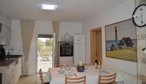a kitchen with a dining table with a clock on the wall at Marina in Čapljina +19 photos