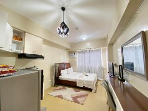 a small room with a bed and a kitchen at 1008 T2 Avida Tower Atria Comfy Cozy in Iloilo City
