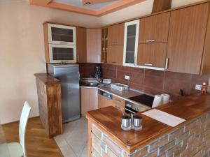 a kitchen with wooden cabinets and a stainless steel refrigerator at Apartment Emir in Mostar