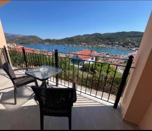 a balcony with a table and chairs and a view of the water at Orizon Sea View in Vathi