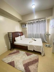 a bedroom with a bed with a rug on the floor at 1008 T2 Avida Tower Atria Comfy Cozy in Iloilo City +14 photos