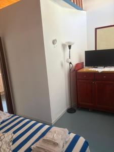 a bedroom with a bed and a desk and a lamp at Villetta Darsena con piscina gratuita dal 18 Luglio al 30 Agosto in Vulcano
