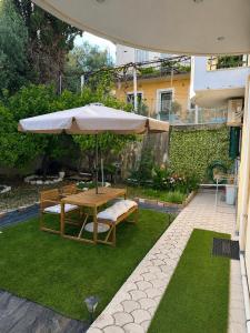 a patio with a table and an umbrella at Nefeli’s guest house in Nydri