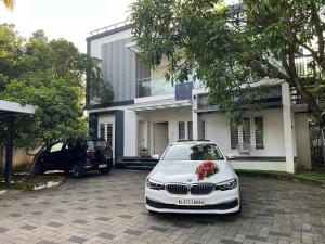 a white car parked in front of a house at THEStay in Alwaye +4 photos