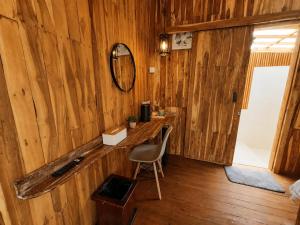 a room with a wooden wall with a desk and a chair at Glamour camping bedugul in Bedugul
