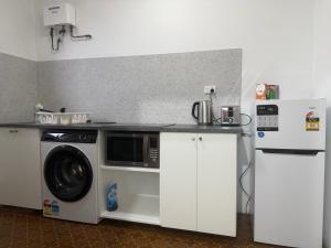 a kitchen with a washing machine and a refrigerator at Como Beach Apartment 2 in Perth
