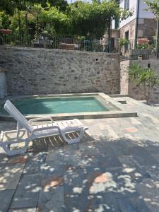 a swimming pool with a chaise lounge and a chair at Quinta Casa Do Quintal in Lamego