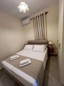 a bedroom with a bed with two white towels on it at Orizon Sea View in Vathi