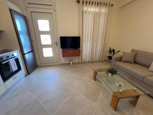 a living room with a couch and a tv at Orizon Sea View in Vathi
