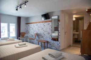a bedroom with two beds and a mirror at Flora in Tinos