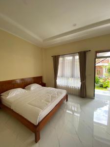 a bedroom with a bed and a large window at SADAMA Cottage in Tuktuk Siadong