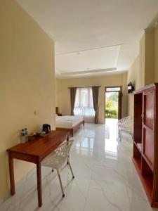 a living room with a desk and a bed in a room at SADAMA Cottage in Tuktuk Siadong