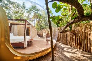 a bedroom in a dome tent on a wooden deck at Astral Tulum in Tulum