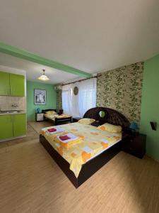 a bedroom with a large bed in a room with green walls at Deskom Žuta Vila in Veliko Gradište