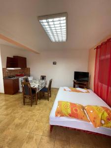 a bedroom with a bed and a table with chairs at Deskom Žuta Vila in Veliko Gradište