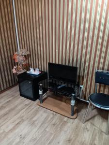 a living room with a television and a table at Asia Hotel in Târgu Jiu