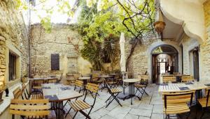 a restaurant with tables and chairs in a building at LE PATIO in Grignan