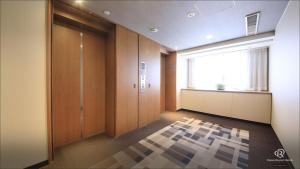 an empty hallway with a door and a window at Daiwa Roynet Hotel Kobe Sannomiya in Kobe +28 photos