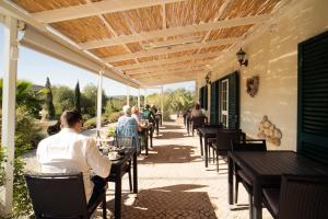 a group of people sitting at tables on a patio at Quinta da Luz - A Luxury Boutique B&B in Silves