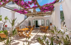 a patio with tables and chairs and purple flowers at alle Stelle b&b by FM, Capri Stays in Anacapri